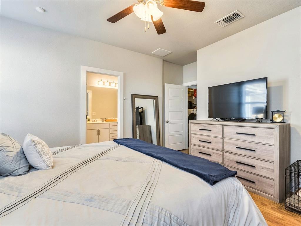 7001 Brick Slope Path Austin, TX 78744 - Photo 14 of 27 Bedroom featuring light wood-style floors, ceiling fan, and connected bathroom