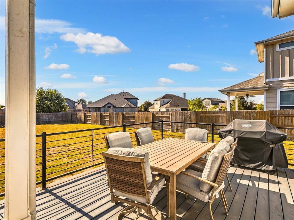 7001 Brick Slope Path Austin, TX 78744 - Photo 23 of 27 Wooden terrace featuring outdoor dining area, a residential view, a grill, and a fenced backyard
