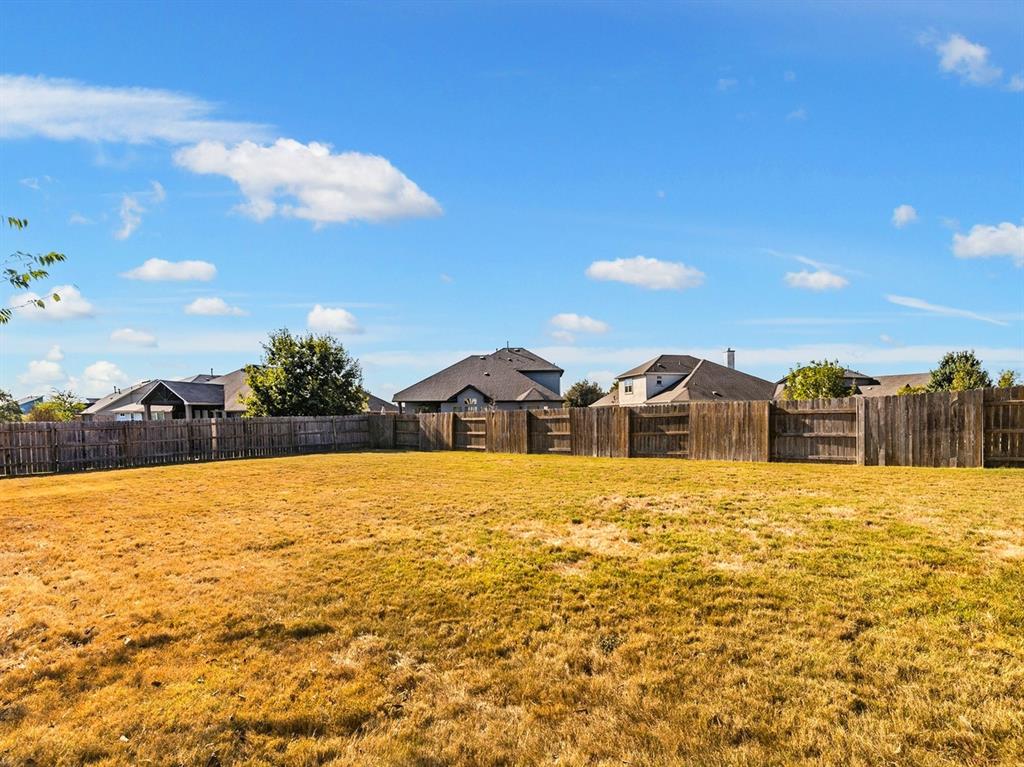 7001 Brick Slope Path Austin, TX 78744 - Photo 26 of 27 Fenced backyard with a residential view