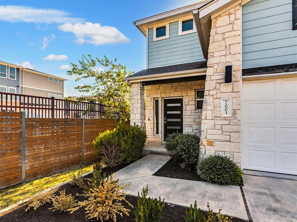 7001 Brick Slope Path Austin, TX 78744 - Photo 3 of 27 Doorway to property featuring stone siding and a garage