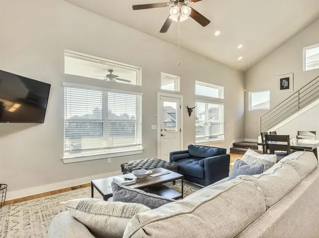 a living room with furniture a flat screen tv and a large window