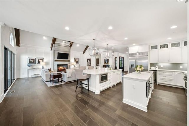 a bedroom with a large bed a flat tv screen and a dresser