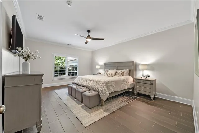 a view of a white house with a big yard plants and large trees