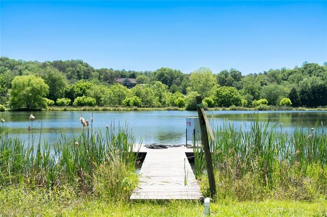 a view of a dining room and livingroom with furniture wooden floor a rug and a chandelier