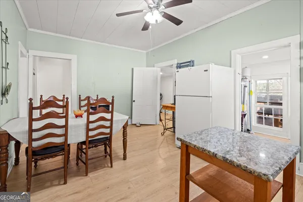 a kitchen with stainless steel appliances granite countertop a dining table chairs and refrigerator