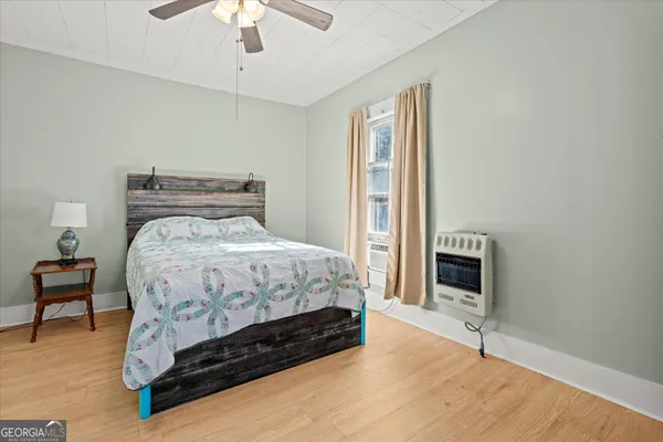 a bedroom with a bed chair and a fireplace