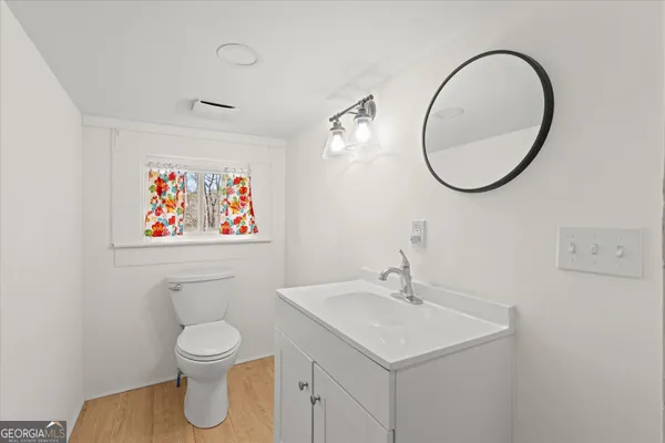 a bathroom with a toilet a sink and a mirror