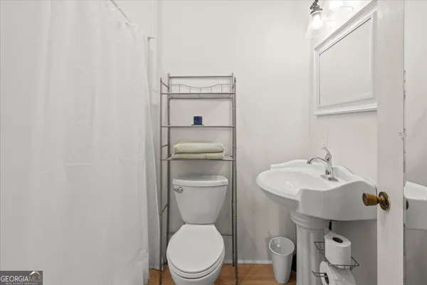 a bathroom with a toilet a sink and mirror