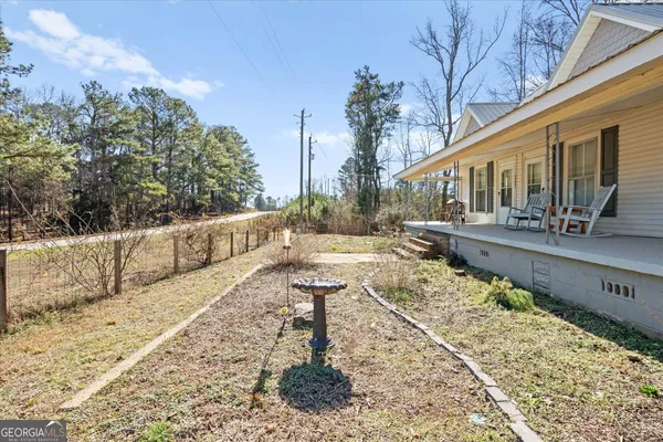 a view of a house with backyard and sitting area