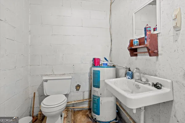 a bathroom with a sink toilet and a mirror