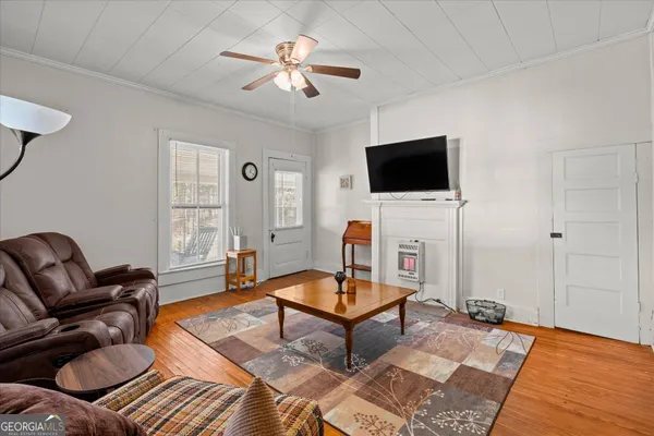 a living room with furniture a flat screen tv and a window
