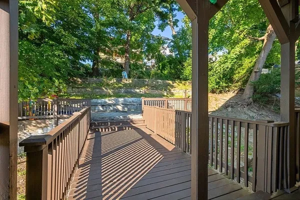 a view of a balcony with wooden floor and fence