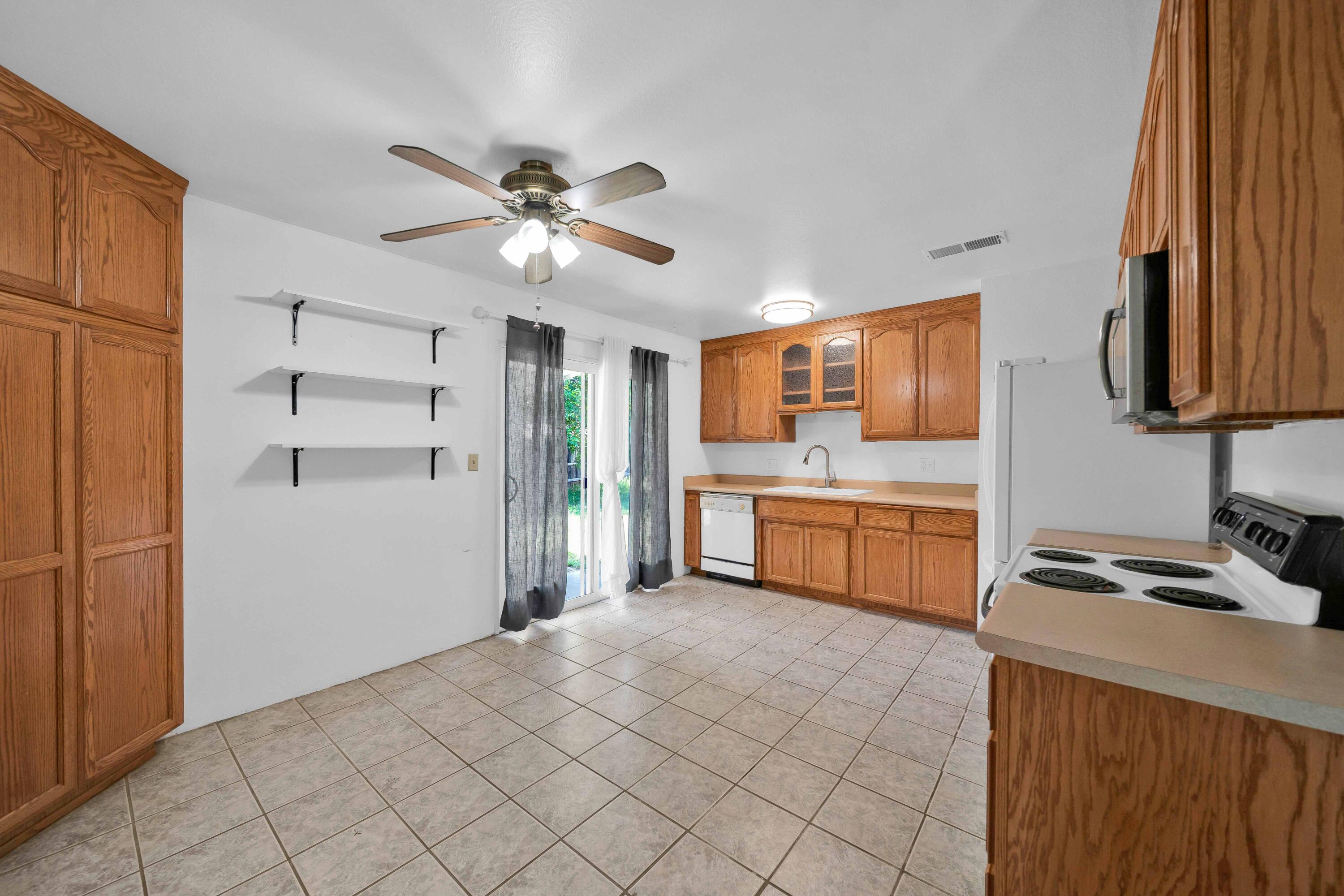 1945 Luning Street Red Bluff, CA 96080 - Photo 6 of 23 a kitchen with kitchen island white cabinets and refrigerator