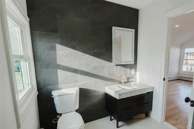 a bathroom with a sink mirror vanity and toilet
