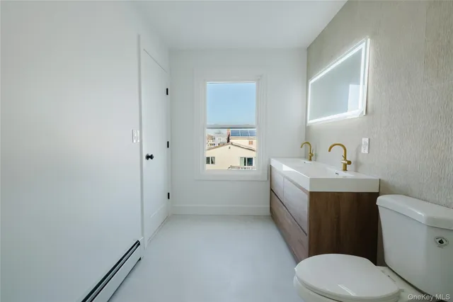 a white toilet sitting next to a bathroom sink