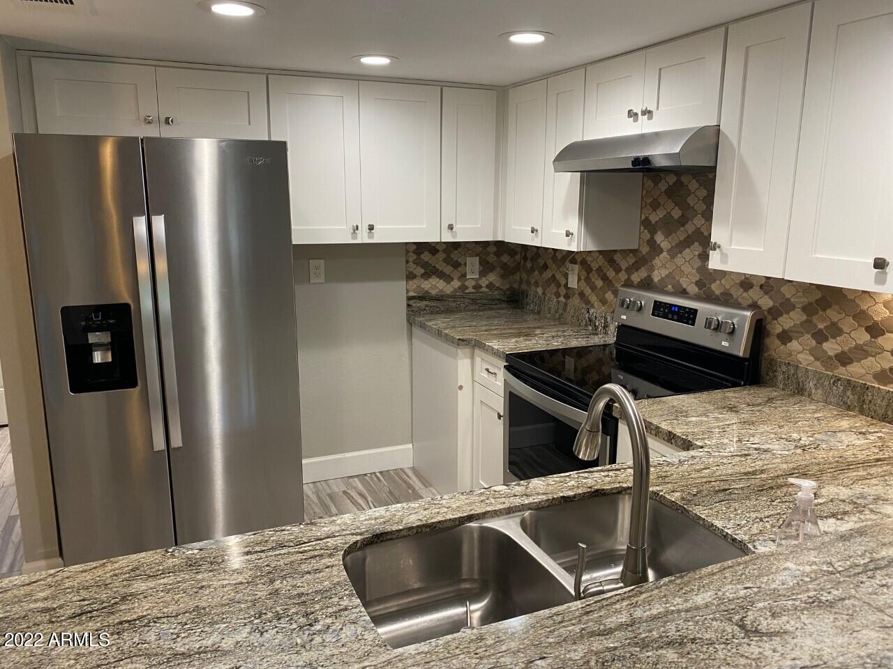 a kitchen with a refrigerator sink and stove