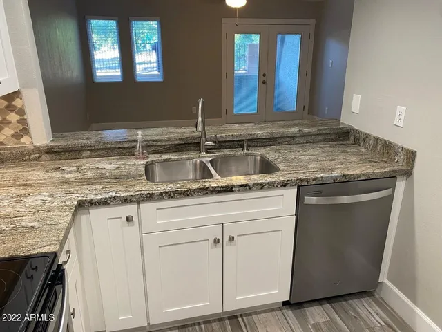 a kitchen with granite countertop a sink and a stove