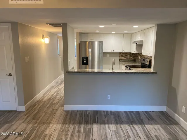 a view of a kitchen with wooden floor and electronic appliances