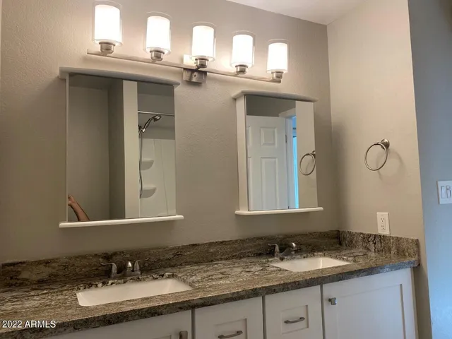 a bathroom with a granite countertop sink and a mirror