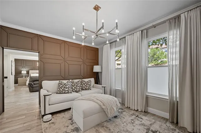 a spacious bedroom with a bed chandelier and a window