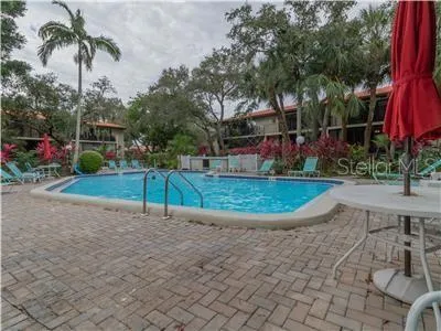 a view of a house with a yard and palm trees