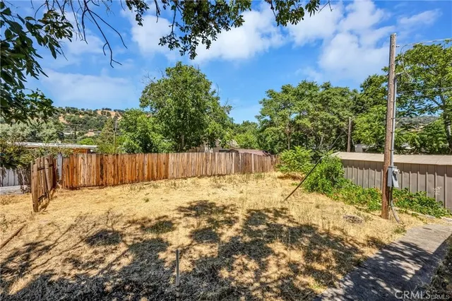 a view of a yard with wooden fence
