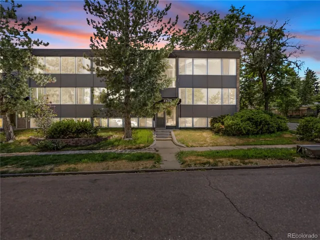 a front view of a residential apartment building with a yard