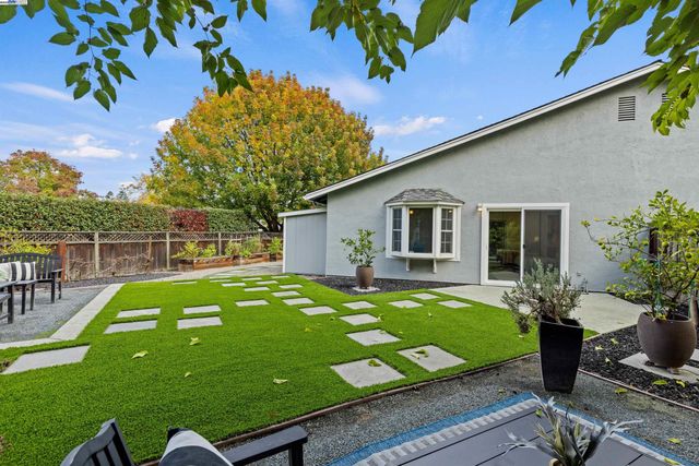 a view of house with backyard and furniture