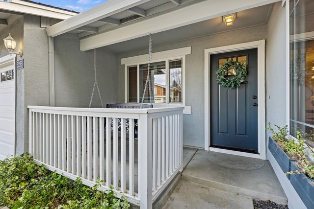 a view of a porch with a table and chair and potted plants