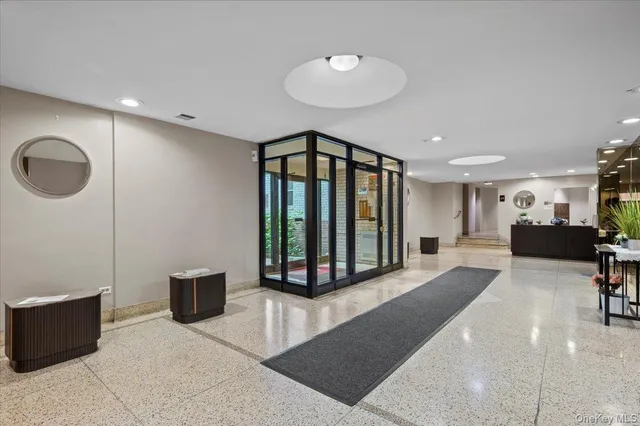 a living room with furniture a mirror and a ceiling fan