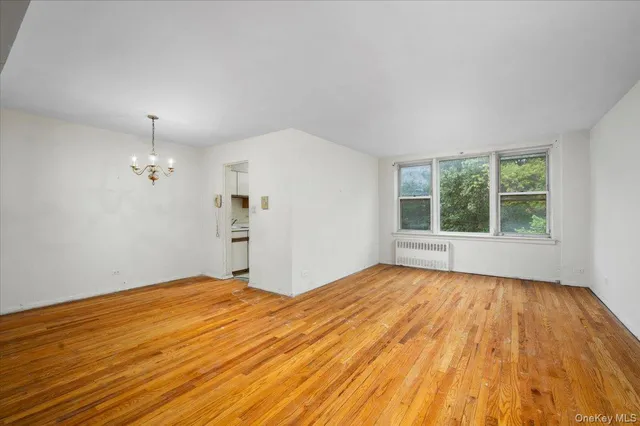 a view of empty room with wooden floor and window