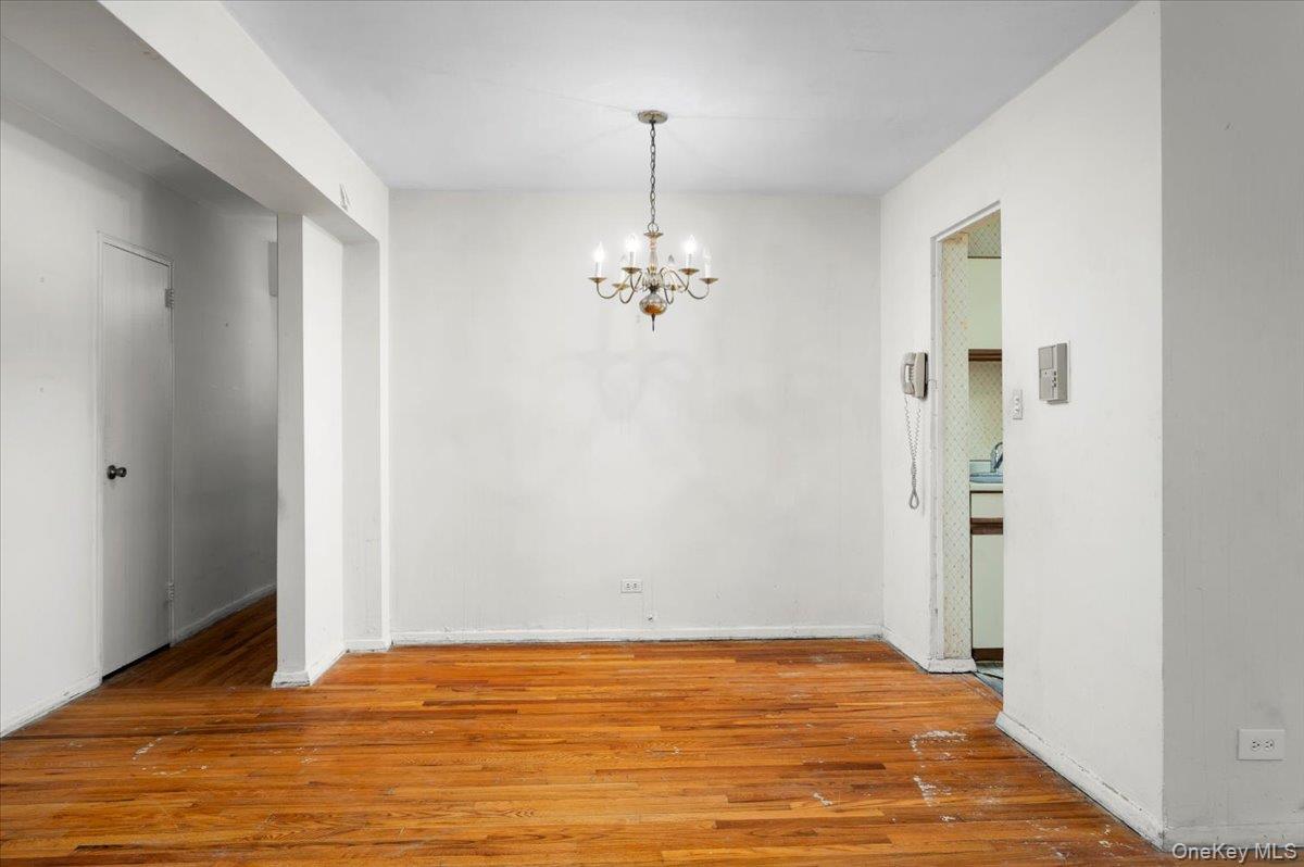 4320 Van Cortlandt Park East, Unit 4C Bronx, NY 10470 - Photo 9 of 21 a view of a livingroom with wooden floor and a chandelier