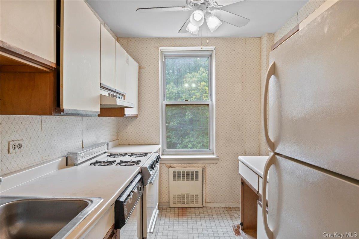 4320 Van Cortlandt Park East, Unit 4C Bronx, NY 10470 - Photo 10 of 21 a kitchen that has a sink a stove and a window
