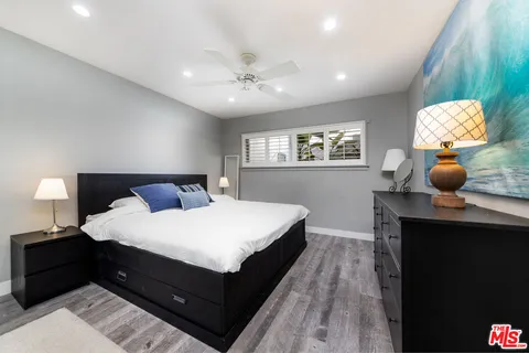 a bedroom with a bed and painting on the wall