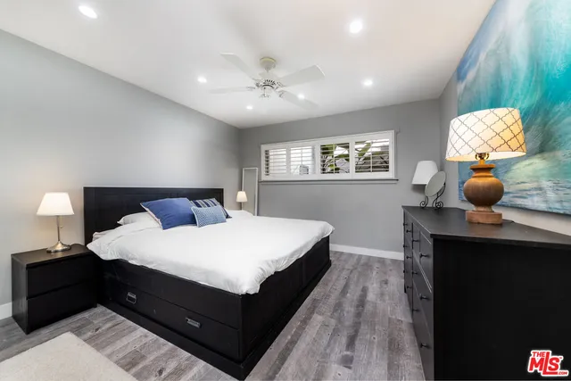 a bedroom with a bed and painting on the wall