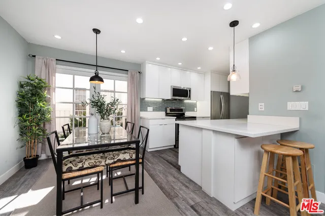 a kitchen with a table chairs refrigerator and microwave
