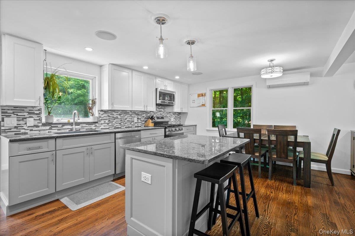 105 High St Extension Mount Kisco, NY 10549 - Photo 21 of 38 a kitchen with stainless steel appliances granite countertop wooden floor dining table and chairs