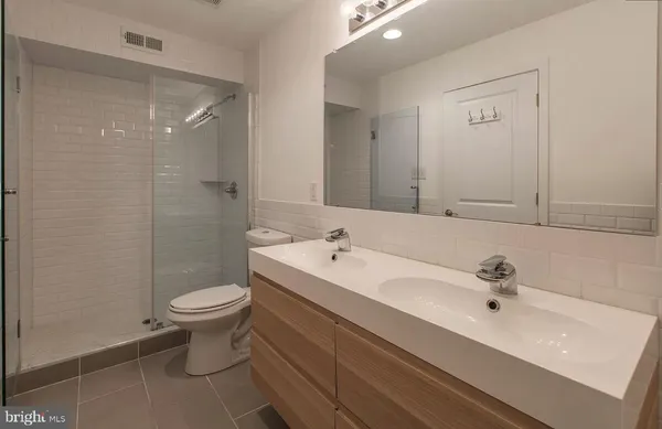 a bathroom with a sink toilet a mirror and shower