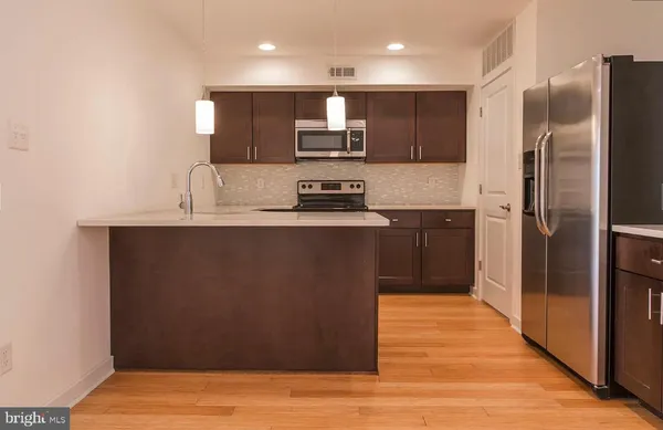 a kitchen with stainless steel appliances granite countertop a refrigerator a sink a stove and oven