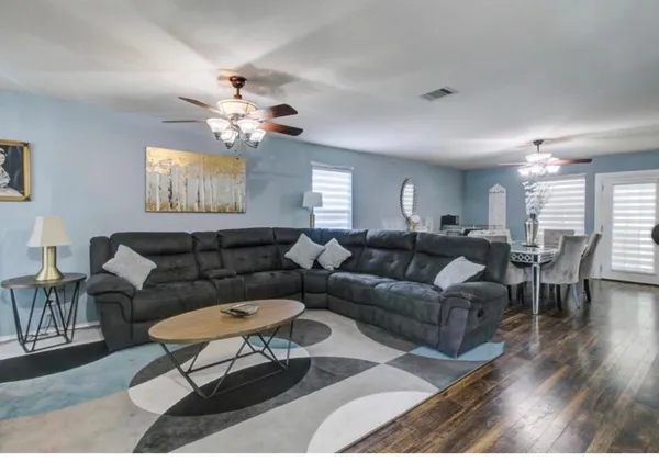 a living room with furniture a chandelier and a rug