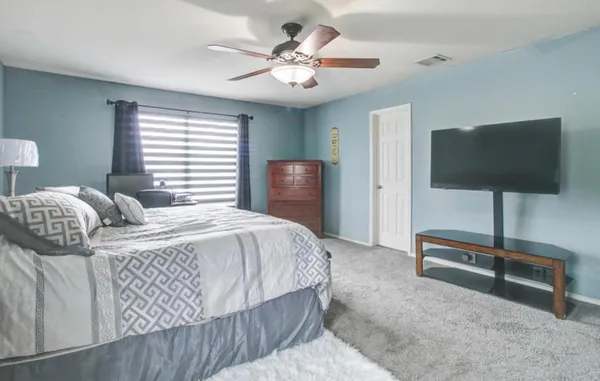 a bedroom with a bed and a flat screen tv