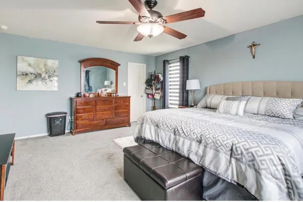 a spacious bedroom with a bed and a chandelier