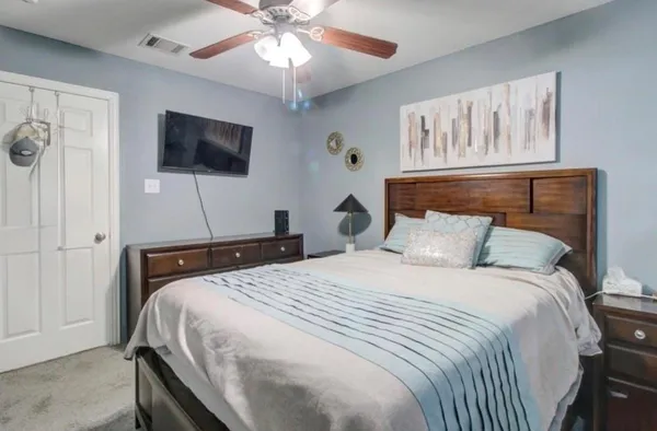 a bedroom with a bed and a flat screen tv