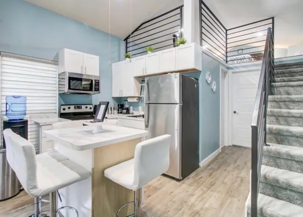 a kitchen with stainless steel appliances a refrigerator and a stove top oven