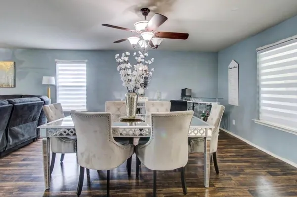 a view of a dining room with furniture a chandelier and wooden floor