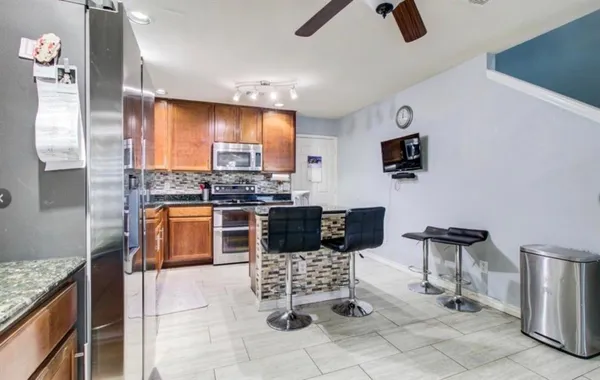 a kitchen with stainless steel appliances kitchen island granite countertop a sink and cabinets