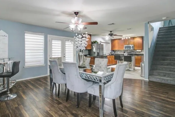 a view of a dining room with furniture a chandelier and wooden floor