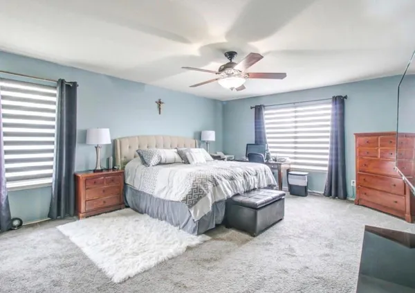 a spacious bedroom with a bed and a chandelier