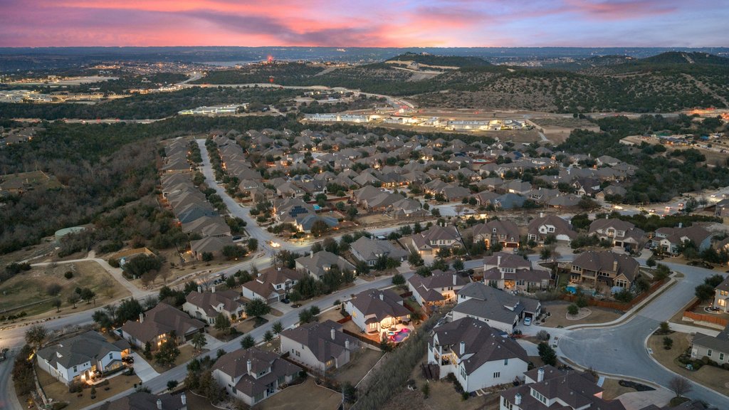 5812 Davenport Divide Road Austin, TX 78738 - Photo 38 of 40 As the sky turns pink and gold, the neighborhood settles into that unmistakable Hill Country calm. Rolling terrain, winding streets, and rooftops glowing in the last light of day remind you why people choose this view.