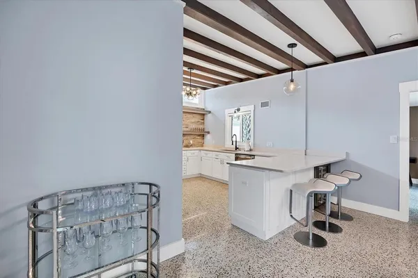 a kitchen with stainless steel appliances a refrigerator a stove and white cabinets